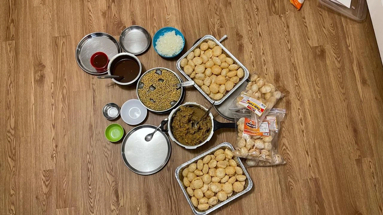 An overhead photo of a pani puri spread on a wooden table